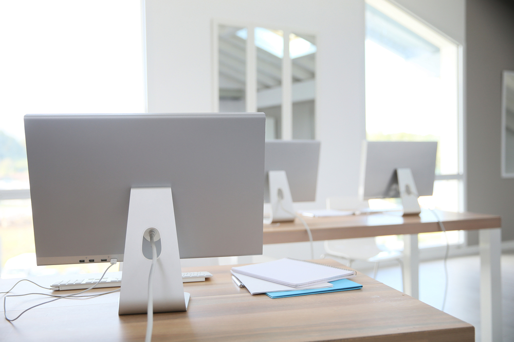 Desktop computers set on tables in classroom